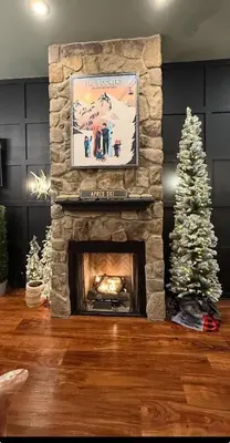 a living room with a stone fireplace with a christmas tree at Modern Hunter Mountain Condo Steps from Slopes in Hunter