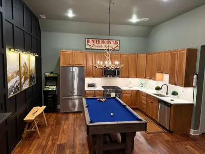 a kitchen with a pool table in the middle of it at Modern Hunter Mountain Condo Steps from Slopes in Hunter