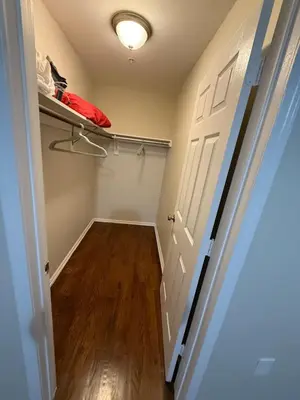 a closet with a door and a red pillow on a shelf at COZY 3 bedroom APT near EWR Downtown NYC in Newark