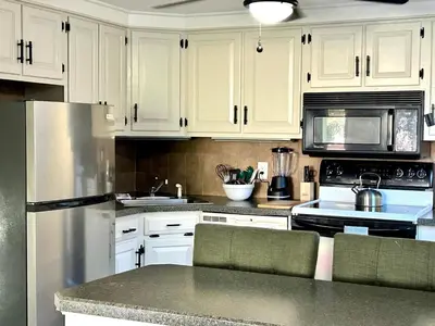 a kitchen with white cabinets and a stainless steel refrigerator at Litchfield Retreat, Wineries, Foliage & Skiing in Torrington
