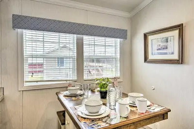 a dining room table with dishes on it with a window at Country Escape near Camps & Ski in Pleasant Mount