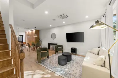 a living room with a couch and a tv at 10-1 Stylish Townhouse Oasis in Greenpoint in Brooklyn