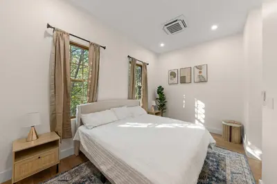 a white bedroom with a bed and a window at 10-1 Stylish Townhouse Oasis in Greenpoint in Brooklyn