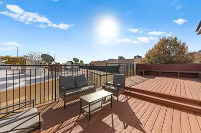 a patio with two chairs and a table on a deck at 10-1 Stylish Townhouse Oasis in Greenpoint in Brooklyn