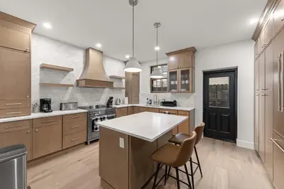 a kitchen with wooden cabinets and a white counter top at 10-1 Stylish Townhouse Oasis in Greenpoint in Brooklyn