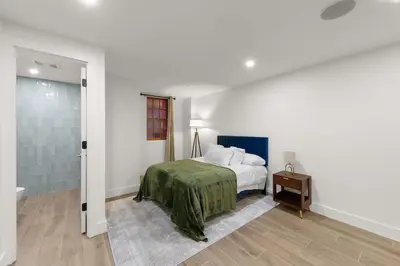 a bedroom with a bed with a green blanket at 10-1 Stylish Townhouse Oasis in Greenpoint in Brooklyn