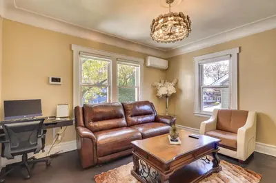 a living room with a leather couch and a desk at Easy Commute to Newark and NYC! Extended Stay Unit in Irvington