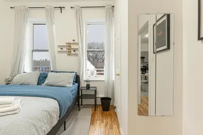 a bedroom with a bed and two windows at Modern Comfort 2BR with Washer & Dryer Near Subway & LGA in Corona
