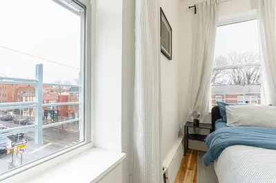 a bedroom with a bed and a large window at Modern Comfort 2BR with Washer & Dryer Near Subway & LGA in Corona