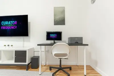 a desk with a computer and a monitor and a chair at Modern Comfort 2BR with Washer & Dryer Near Subway & LGA in Corona