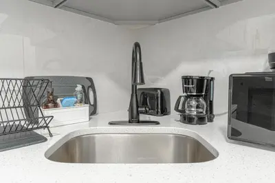 a kitchen counter with a sink and a microwave at Modern Comfort 2BR with Washer & Dryer Near Subway & LGA in Corona