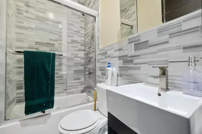 a bathroom with a white toilet and a sink at Spacious Central Park Apartments in New York