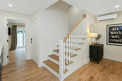 a white staircase in a home with wood floors at Glenbrook Suites in Stamford