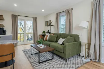 a living room with a green couch and a table at Glenbrook Suites in Stamford