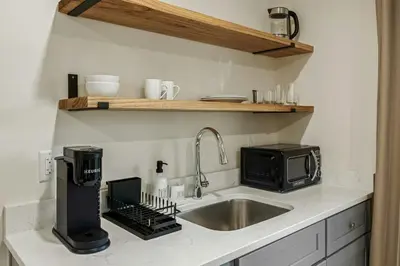 a kitchen counter with a sink and a microwave at Glenbrook Suites in Stamford