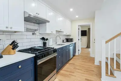 a kitchen with white cabinets and a stove top oven at Glenbrook Suites in Stamford