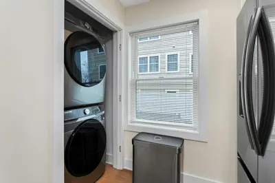 a laundry room with a washer and dryer and a window at Glenbrook Suites in Stamford