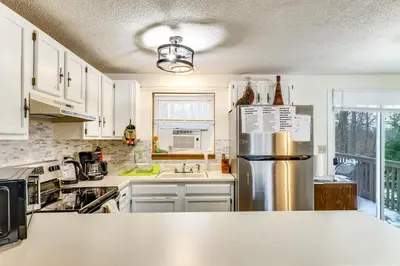 a kitchen with white cabinets and a stainless steel refrigerator at Ski, Swim and Hike! Family Home in Tobyhanna in Tobyhanna