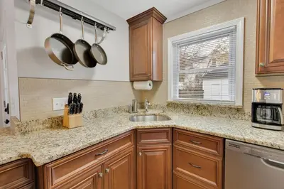 a kitchen with wooden cabinets and a sink at The Game House Arcade West Hartford in West Hartford