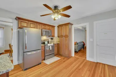 a kitchen with a refrigerator and a ceiling fan at The Game House Arcade West Hartford in West Hartford