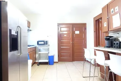a kitchen with a stainless steel refrigerator and white chairs at 1 Bus Stop To NYC Room-Free Parking in Hillside