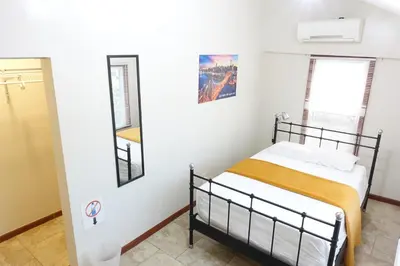 a bedroom with a bed and two windows at 1 Bus Stop To NYC Room-Free Parking in Hillside