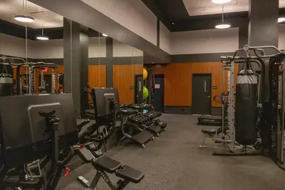 a gym with a bunch of equipment in a room at Lux Bronx Apt Rooftop, Pool, Gym, Cinema in Mott Haven