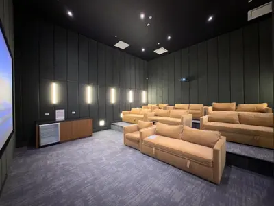 a waiting room with leather couches and a television at Lux Bronx Apt Rooftop, Pool, Gym, Cinema in Mott Haven
