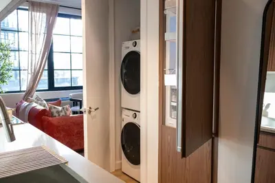 a laundry room with a washer and dryer at Lux Bronx Apt Rooftop, Pool, Gym, Cinema in Mott Haven