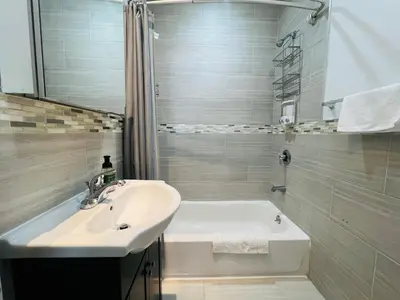 a bathroom with a sink and a bath tub and a sink at The Marlow Midtown in New York