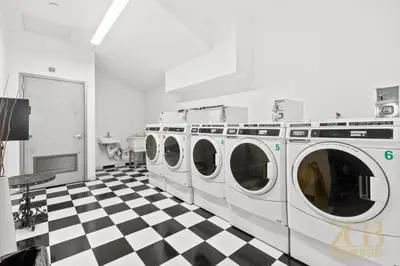 a laundry room with four washing machines on a checkered floor at Gorgeous and Fully Equipped Luxury 1 Bedroom Apt in New York