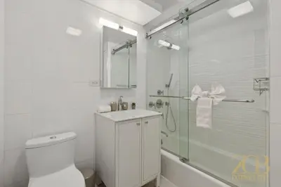 a bathroom with a shower and a toilet and a sink at Spacious 1-Bedroom Retreat Near Central Park in New York