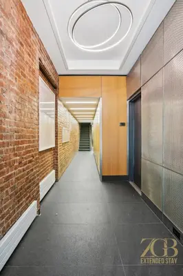 a hallway with a brick wall and a ceiling at Spacious 1-Bedroom Retreat Near Central Park in New York