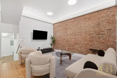 a living room with a brick wall at Spacious 1-Bedroom Retreat Near Central Park in New York