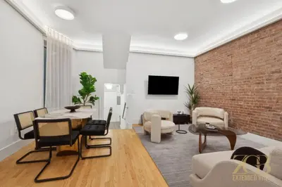 a living room with a brick wall and a table and chairs at Spacious 1-Bedroom Retreat Near Central Park in New York