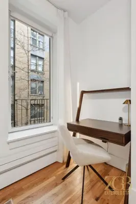 a desk and a chair in a room with a window at Spacious 1-Bedroom Retreat Near Central Park in New York