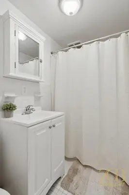 a bathroom with a white shower curtain and a sink at Gorgeous 2 Bedroom Apt in UES in New York
