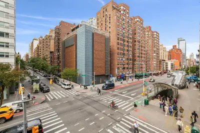 a busy city street with cars and pedestrians and buildings at Gorgeous 2 Bedroom Apt in UES in New York