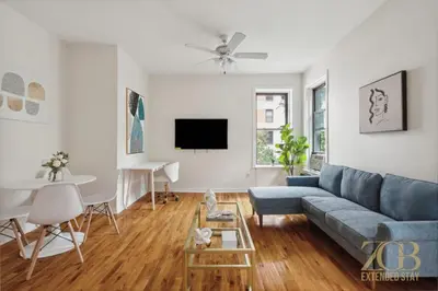 a living room with a blue couch and a table at Gorgeous 2 Bedroom Apt in UES in New York