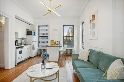 a living room with a green couch and a table at Beautiful 1-Bedroom in the Upper East Side in New York
