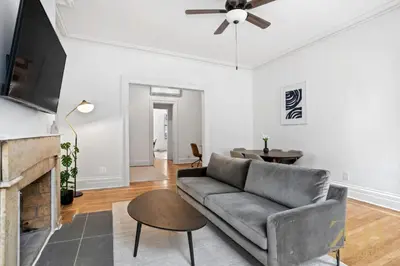 a living room with a couch and a ceiling fan at Sun-Filled Brownstone Apt in Prime Chelsea in New York