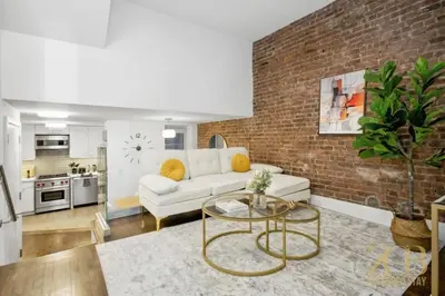 a living room with a white couch and a brick wall at Gorgeous 2-Bedroom Retreat in the Upper East Side in New York