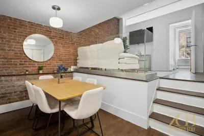 a dining room with a table and a brick wall at Gorgeous 2-Bedroom Retreat in the Upper East Side in New York