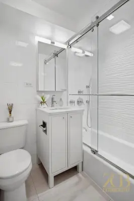 a white bathroom with a toilet and a shower at Gorgeous 2-Bedroom Retreat in the Upper East Side in New York