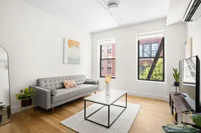 a living room with a couch and a table at Renovated 2 Bed 2 Bath Apt in Prime Midtown - Elevator - Laundry in New York