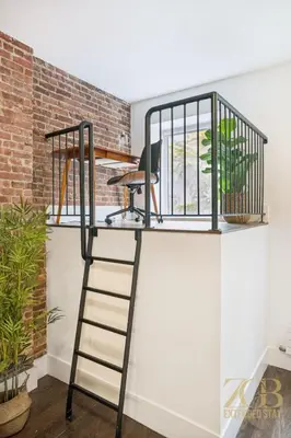 a desk on top of a shelf with a ladder at Charming UES 1BR Duplex Near Central Park in New York