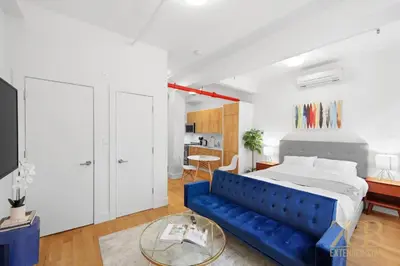 a bedroom with a blue couch and a bed at Beautifully Renovated Studio in Prime Manhattan in New York