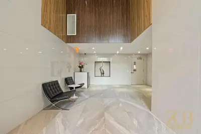 a large white room with a chair and a table at Stylish 2-Bedroom Near Central Park - Laundry - Elevator in New York