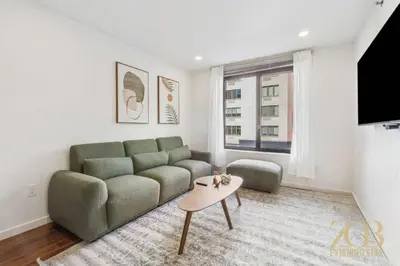 a living room with a couch and a table at Stylish 2-Bedroom Near Central Park - Laundry - Elevator in New York