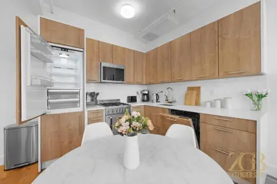 a kitchen with a table with a vase of flowers on it at Beautifully Renovated 1 bedroom in Prime Manhattan in New York